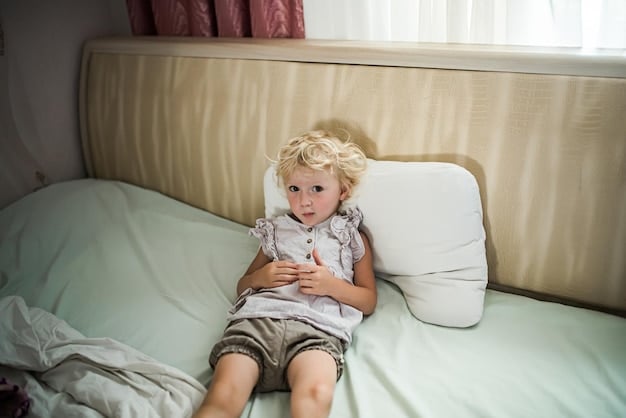 A child sitting on a bed, looking worried with hands on their stomach, suggesting physical discomfort related to anxiety.