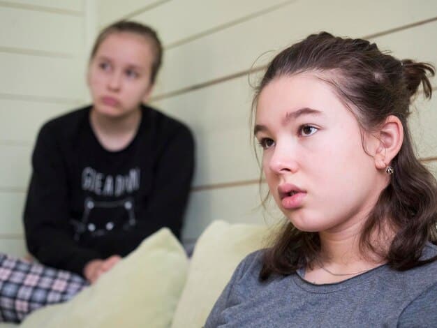 A close-up shot of a parent mediating a dispute between two young siblings. The parent is kneeling to be at eye level with the children, actively listening with a calm and empathetic expression. The children's expressions show frustration but also a willingness to resolve the issue.