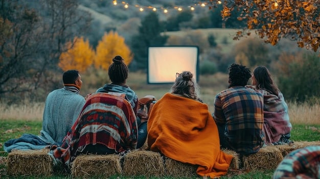 A group of families sitting on blankets in a park, watching an outdoor movie projected onto a large screen. Children are laughing and eating popcorn, while parents are chatting and relaxing. The scene is warm and inviting, with string lights illuminating the area.