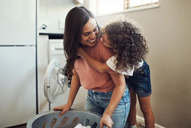 A parent and two children (ages 8 and 11) laughing while doing laundry together in a well-lit laundry room. The children are folding clothes and making funny faces, while the parent is supervising and smiling.