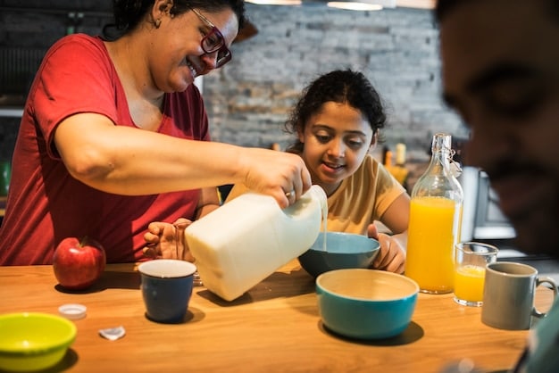 A young family is shown packing lunches at a local soup kitchen. The parents are helping their young children assemble sandwiches and pack fruit into lunch bags for the homeless, all with smiles and an atmosphere of warmth and caring.