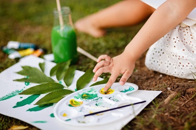Close-up shot of a child's hands holding a paintbrush, applying vibrant colors to a canvas outdoors, with blurred greenery in the background.