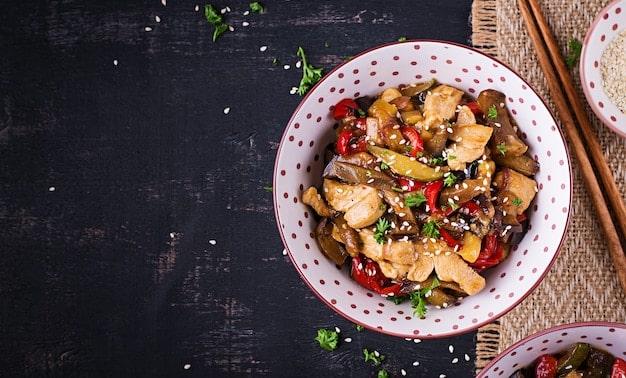 A vibrant shot of a Chicken and Vegetable Stir-Fry, featuring tender chicken pieces and a mix of colorful veggies like broccoli, bell peppers, snap peas, and carrots. The stir-fry is coated in a glossy, savory sauce, served over a bed of fluffy rice, and garnished with sesame seeds.