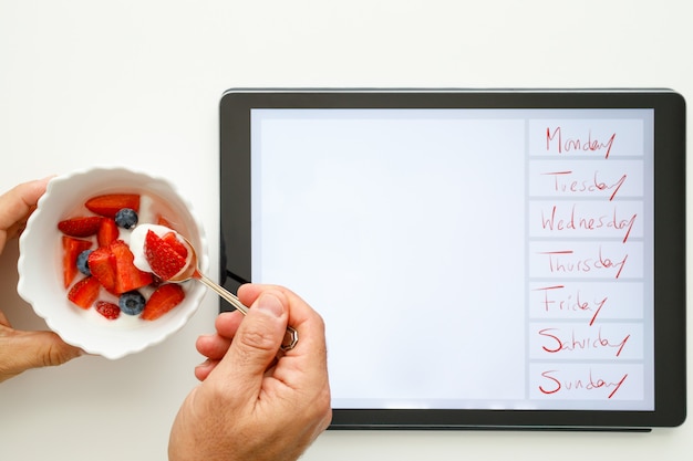 A close-up shot of a handwritten weekly meal plan on a magnetic whiteboard, with sticky notes displaying various toddler-friendly meal and snack ideas attached around it.