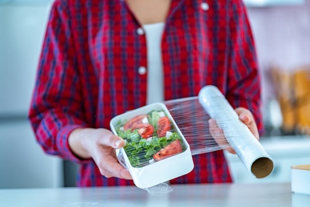 A person using a reusable container to store leftover food in a refrigerator, emphasizing proper food storage techniques to minimize waste.