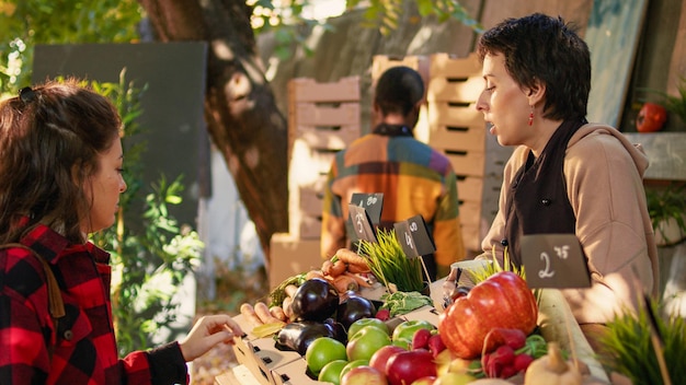 A colorful farmer's market stall overflowing with fresh, seasonal fruits and vegetables. The focus is on affordable, locally sourced produce, with shoppers browsing and selecting items.