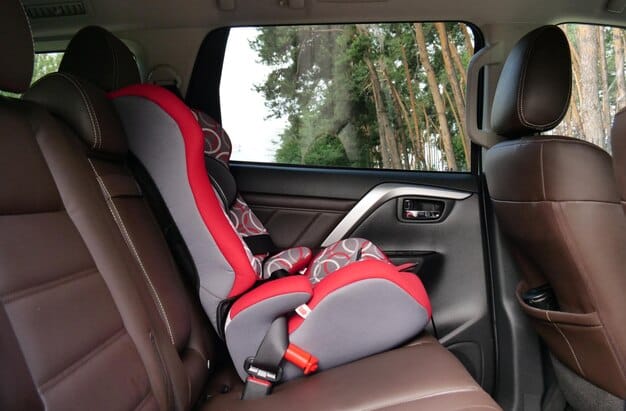 A side view of a convertible car seat installed in a car, demonstrating its adaptability to both rear-facing and forward-facing positions. The image highlights adjustable harness straps and headrest, showcasing its suitability for growing children.