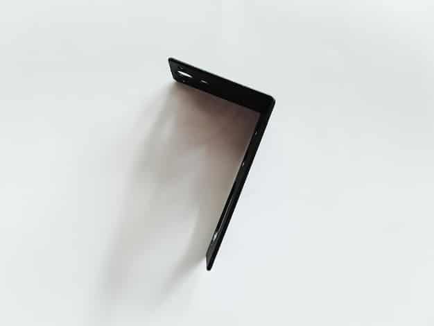 A close-up shot of a clear plastic corner protector securely attached to the sharp corner of a coffee table. The corner protector is transparent and blends in well with the table, showing how it provides safety without being visually obtrusive.