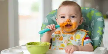 Happy baby eating pureed sweet potato in high chair