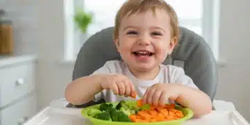 Toddler happily eating a colorful plate of vegetables