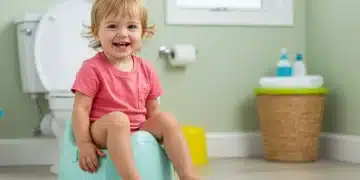 Happy toddler successfully using a child-sized potty chair