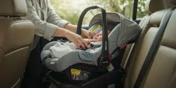 Parent securing newborn in 5-star NHTSA rated car seat for first ride